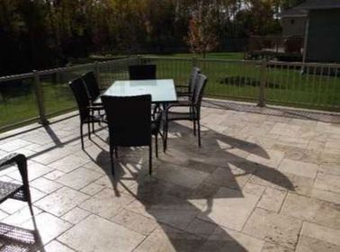 this is a picture of a stamped square and rectangle concrete patio in a backyard on a deck